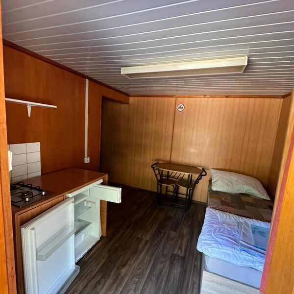Kühlschrank, Gasherd und ein Bett mit Bettwäsche